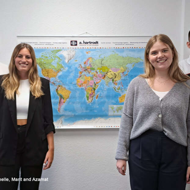 Trainees in front of a world map